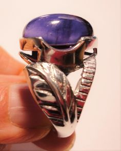 "Amethyst ring with a large pear shaped purple amethyst cabochon gemstone, set in a sterling silver leaf design ring, in a size 6 This vintage ring features a large royal purple amethyst pear amethyst cabochon, set in a solid sterling ring, with a beautiful large leaf embellishment on each side. The ring is a size 6. The polished bezel setting shows off the large, clear and very high quality genuine 16mm x 12mm amethyst jewel. It is stamped \"925\" for solid sterling inside the band. The ring ha Formal Purple Cabochon Amethyst Ring, Hallmarked Oval Cabochon Amethyst Ring, Purple Amethyst Oval Cabochon Ring, Purple Amethyst Teardrop Ring, Purple Teardrop Gemstone Rings, Formal Purple Amethyst Spiritual Ring, Spiritual Oval Purple Amethyst Ring, Formal Spiritual Purple Amethyst Ring, Teardrop Amethyst Ring In Purple