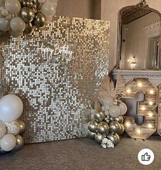 balloons and decorations are on the floor in front of a mirror with lights around it