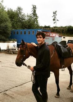 a man standing next to a brown horse