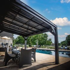 an outdoor dining area next to a pool with chairs and tables under a pergolated roof