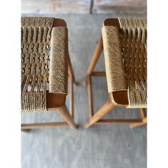 two wooden chairs with woven seats on them