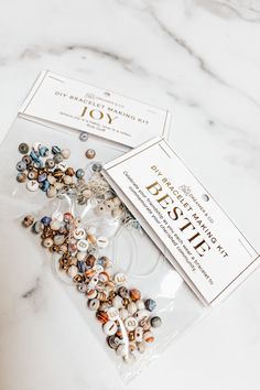 two bags of beads sitting on top of a white table next to a card with the words bestie