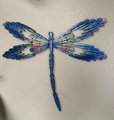 a blue dragonfly is hanging on the wall