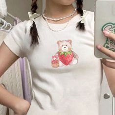 "🌟 Thank you for stopping by GirlyThreadsCo! This strawberry teddy bear baby tee is made to order just for you! This is the perfect tee for coquette lovers, trendy girlycore fans, or is great for everyday wear! 👕 PRODUCT & DESCRIPTION 🛑 PLEASE NOTE: The sizing of this baby tee is not the same as standard US Women's sizes. We recommend you size up 1-2 sizes to achieve the same fitted look as our model photo. This shirt does run small around the arms, shoulder, and bust area and we recommend sizing up. Our Gildan Youth 5000B t-shirts are pure comfort and 100% cotton. Please be sure to check the sizing chart to choose the right size for your preferred fit. Lay your favorite baby tee at home flat and measure armpit to armpit to compare to the size chart in the photos. Also keep in mind that White Bear Design Short Sleeve Tops, White Short Sleeve Top With Bear Design, Cute White T-shirt With Bear Design, Cute Cotton T-shirt With Bear Design, Cute Bear Print Crew Neck T-shirt, Cute Short Sleeve T-shirt With Bear Print, Cute Bear Print Short Sleeve Tops, Cute Bear Print Top With Short Sleeves, Cute Short Sleeve Top With Bear Print