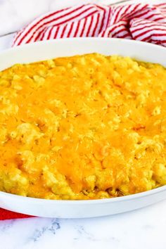 a casserole dish filled with cheese on top of a red and white towel