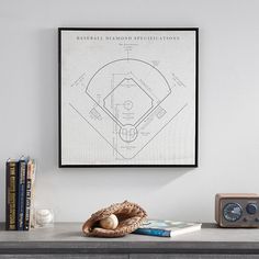 a baseball diamond is on the wall next to books and an alarm clock in front of it