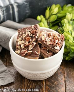 a white bowl filled with chocolate and nuts