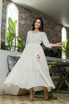 Single Piece Fabric-Cotton Color-White Work-Lace, mirror & embroidery detailing with side tassels Length-Ankle Length Sleeves-3/4th Sleeves Neck-Round Neck Occasion-Casual wear Washing care-Hand wash Anarkali Kurta, White Mirror, Embellished Gown, Embroidery Details, Every Woman, Anarkali, Indian Wear, Ankle Length, White Fabrics