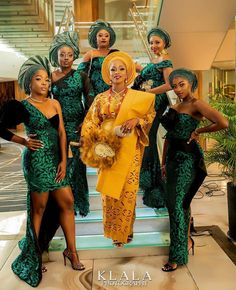 the beautiful african women in green and yellow outfits are posing for a photo on stairs