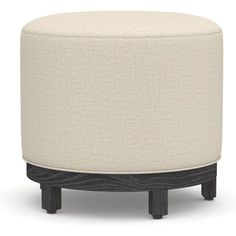 a round ottoman sitting on top of a wooden table next to a white and black stool