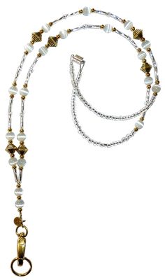 a white and gold beaded necklace with an oval charm hanging from it's end