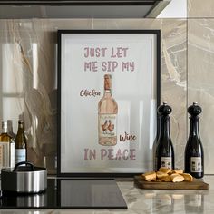 wine bottles and corks are sitting on the counter in front of a framed poster