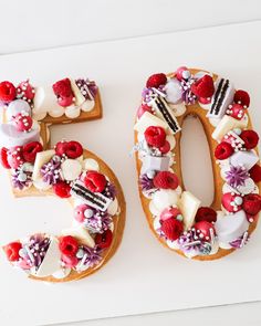 the number 50 is made out of cake and decorated with flowers, berries, and other things