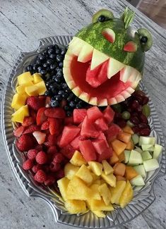 a plate filled with fruits and vegetables shaped like a frog