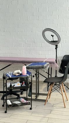 a table with chairs and a camera in front of a white brick wall behind it