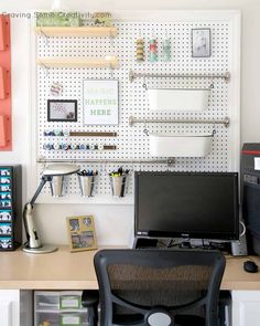 a desk with a computer on it in front of a pegboard and some other office supplies