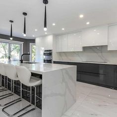 a kitchen with marble counter tops and white chairs