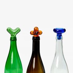 three different colored glass bottles sitting next to each other