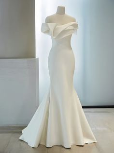 a white wedding dress on display in a room