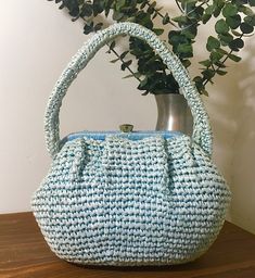 "1950s 1960s Dayne Taylor Pale Blue Raffia Purse, Vintage Top Handle Handbag, Mid Century Accessory Pretty pale blue raffia purse made by Dayne Taylor in the 1950s 1960s that features: Double handle straps. Gold tone metal hardware with a round thumb lift clasp closure that works well and closes tightly. Opens to a pale blue fabric lining with one interior side metal zippered pocket. Dayne Taylor Made In Japan label attached. There are protective feet on the bottom of the bag. Beautiful vintage Blue Retro Evening Bag, Retro Blue Evening Bags, Retro Rectangular Crochet Bag, Retro Handmade Bags For Vintage Fashion, Retro Handmade Blue Bags, Retro Blue Handmade Bags, Vintage Woven Handheld Bag, Vintage Handheld Woven Bag, Vintage Crochet Beach Bag