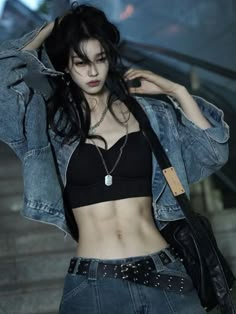 a woman in black top and jean jacket standing next to stairs