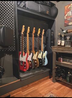 guitars are lined up in the back of a guitar case, with other instruments behind them