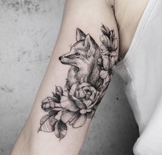 a fox and flowers tattoo on the arm