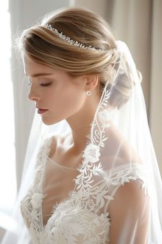 a woman in a wedding dress wearing a veil and tiara with pearls on her head