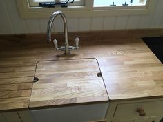 a kitchen counter top with a sink and faucet next to it in front of a window