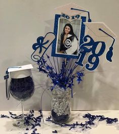 a graduation bouquet in a mason jar with blue and silver confetti