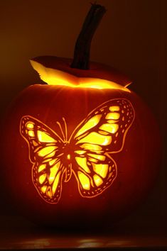 a pumpkin carved to look like a butterfly with the words happy halloween written on it