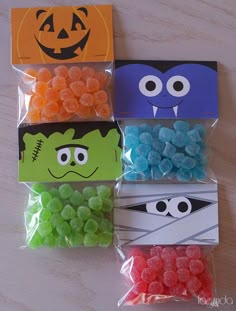 four bags filled with gummy candies in different colors and designs, each bag has an evil face on it