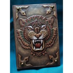 a leather wallet with an image of a tiger's head on the front and side