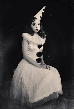 an old black and white photo of a woman in a dress with a cat hat