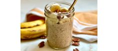 a glass jar filled with oatmeal and bananas on top of a table