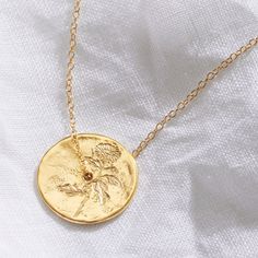 "November birth flower spinner pendant in gold vermeil, delicately hand engraved with a Chrysanthemum flower to symbolise the month of November. This botanical necklace has been handmade in England.  It is hand engraved with a single Chrysanthemum flower and cast in sterling silver, plated with 2.5 microns of 18 carat gold. The gold coin style pendant has a lovely organic texture to the surface to enhance the natural look of the piece. It comes hung on a sterling silver trace chain that has also Rose Gold Medallion Jewelry With Birth Flower, Gold Engraved Necklace For May Birthstone, Gold Birthstone Necklace For Her, Engraved Yellow Gold Coin Necklace As Gift, Gold Birthstone Jewelry With Round Disc, Gold Necklaces With Birth Flower Round Pendant, Engraved Yellow Gold Necklace For May Birthstone, Gold Necklace With May Birthstone In Round Pendant, Gold Engraved Birthstone Necklace For Anniversary