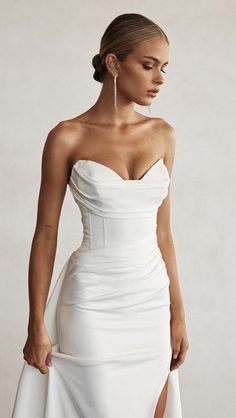 a woman wearing a white dress with high slit