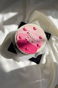 a birthday cake with pink frosting and hearts on it