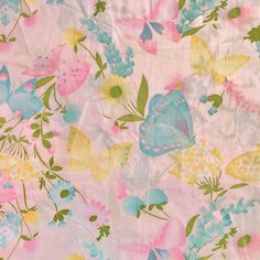 a pink and blue butterfly print fabric with flowers on the bottom, in pastel colors