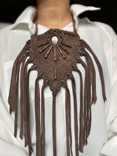 Pocohontas inspired genuine suede nomad western necklace with  long fringe  - neck strap with two buttons for low or high wear. -metal embellishments  -length of  bib 6" (with fringe 14") Adjustable Fringe Tassel Necklace For Festival, Adjustable Tassel Necklace With Fringe For Festivals, Adjustable Tassel Necklace For Festivals, Adjustable Concho Necklaces For Festival, Artisan Adjustable Bib Necklace For Festivals, Artisan Beaded Fringe Necklaces For Festivals, Brown Tassel Jewelry For Festivals, Festival Fringe Choker Necklace, Brown Tassel Necklace For Festival