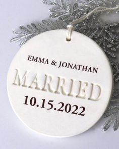 a white ceramic ornament with the words married on it and snowflakes