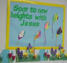 a bulletin board with flowers and kites in the grass that says soar to new heights with jesus