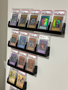 several different cards are on display in a room with black shelving and white walls