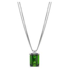 Gorgeous necklace, perfect for every day wear. Designed and created alongside matching earrings and ring that can be found in separate listings. Necklace Details: Emerald Cut Chrome Green Tourmaline (15.6 x 11.3 mm) weighing 11.58 Carats Very slightly bluish Green (vslbG) in color with dark tone and moderate saturation Trapezoid-shaped Diamond weighing 0.66 Carats Total Gem Weight: 12.24 Carats Overall Weight: 10 grams Finished Pendant Measurements: Length: 20.92 mm Width: 12.61 mm Double Box Ch Chrome Green, Chrome Tourmaline, Bluish Green, Green Tourmaline, Gorgeous Necklaces, Emerald Cut, Diamond Pendant, Matching Earrings, Chains Necklace