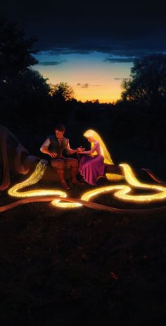 a man and woman sitting on top of a bench next to a light sculpture in the dark