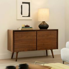 a lamp is sitting on top of a wooden cabinet