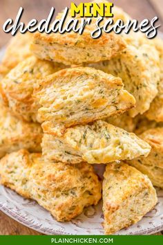 a white plate topped with cheesy biscuits on top of a wooden table