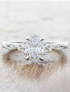 an oval cut diamond ring with two side stones