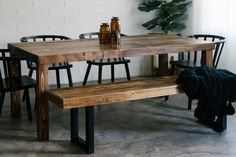 a wooden table sitting next to two black chairs