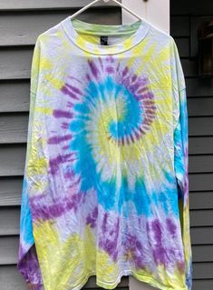 a tie - dyed shirt hanging on a clothes hanger